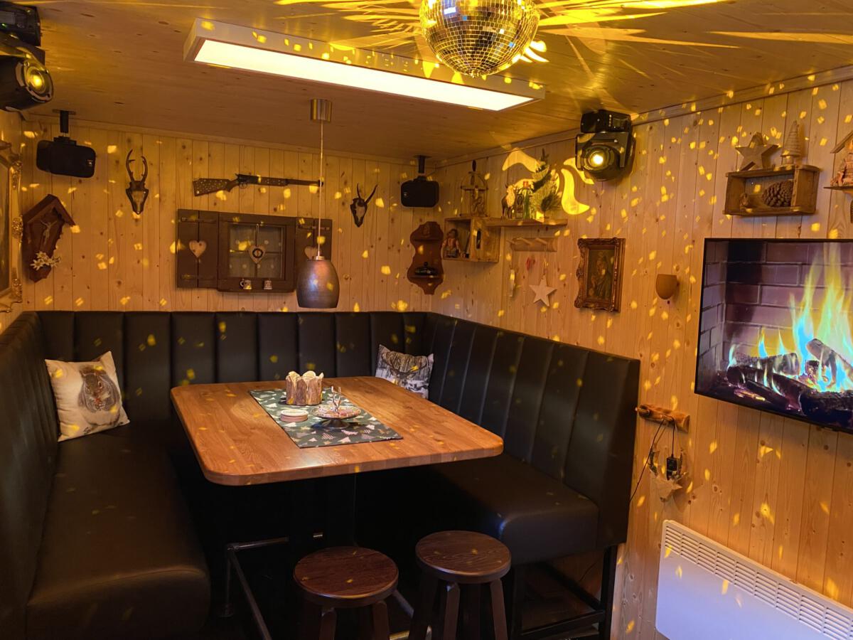 TinyClub Lounge mit Kaminbildschirm und Lichteffekten