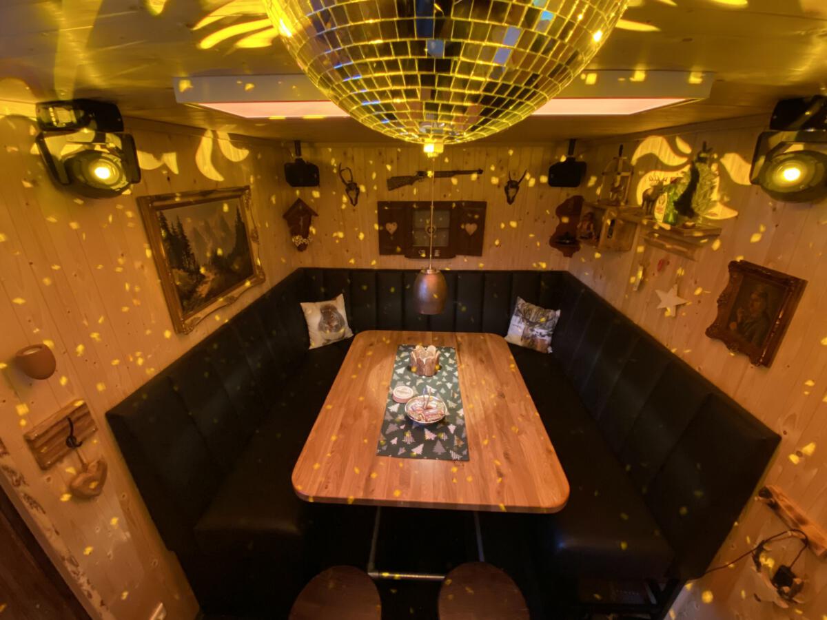 Sitzecke im TinyClub mit Discokugel und warmem Licht